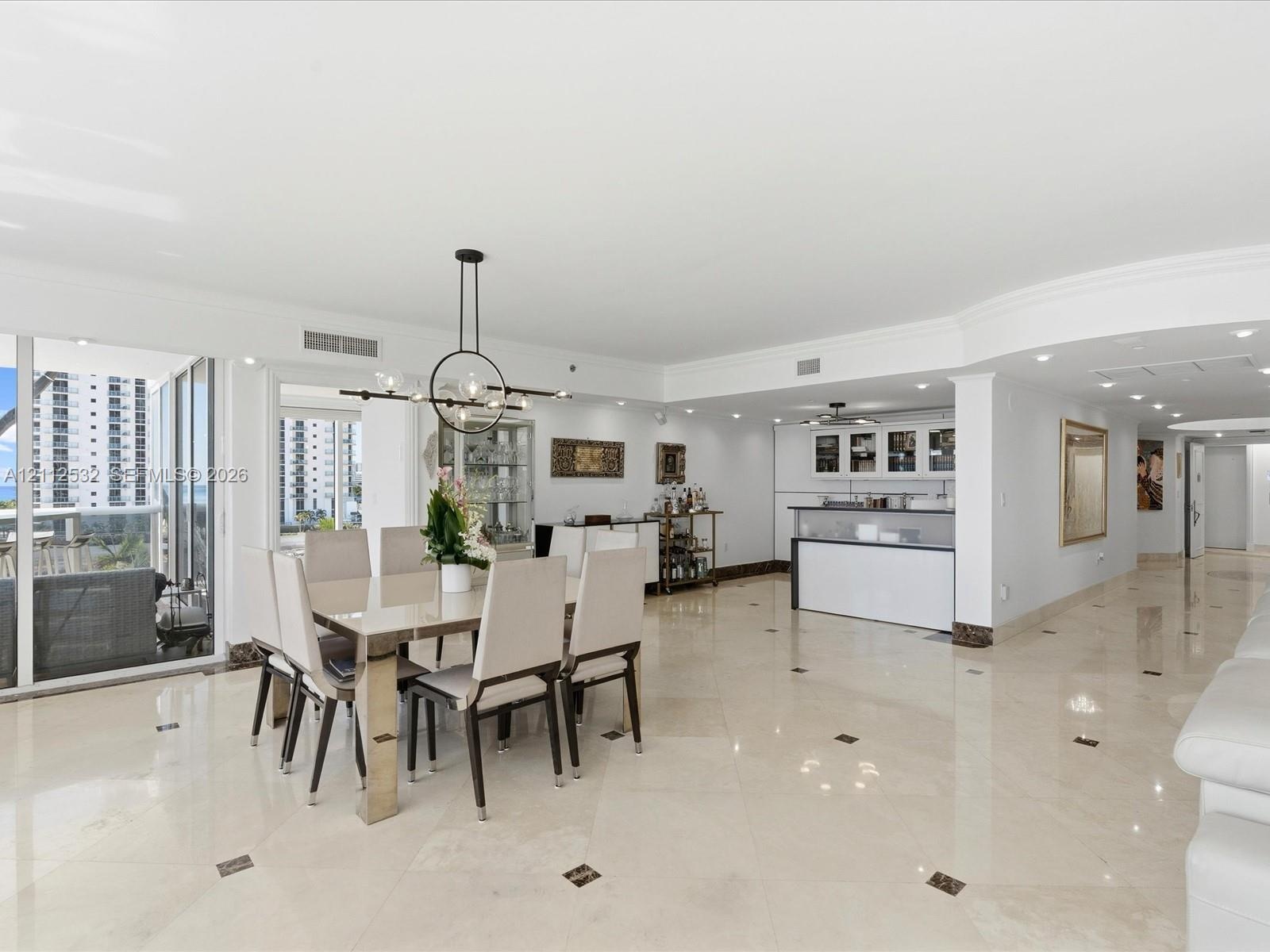 Open-concept area featuring polished stone flooring with decorative inlays, a built-in wet bar with cabinetry, recessed lighting, a modern multi-arm c