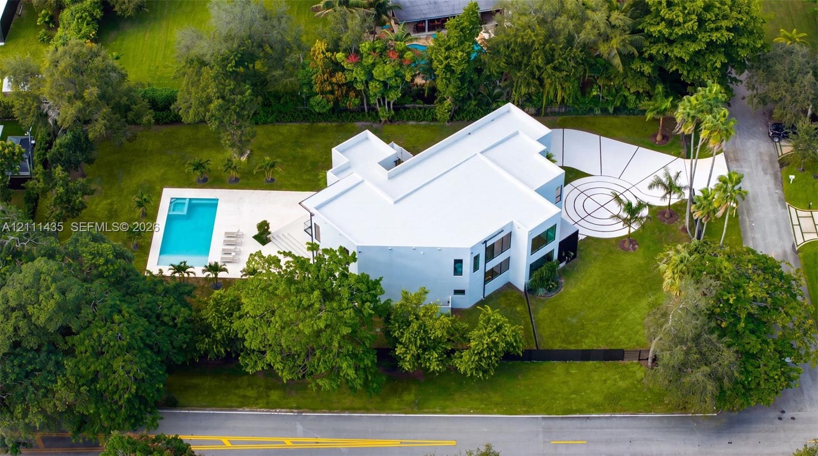 Modern multi-level estate featuring a flat-roof architectural design, a private swimming pool with an integrated spa, expansive lawn, and a decorative