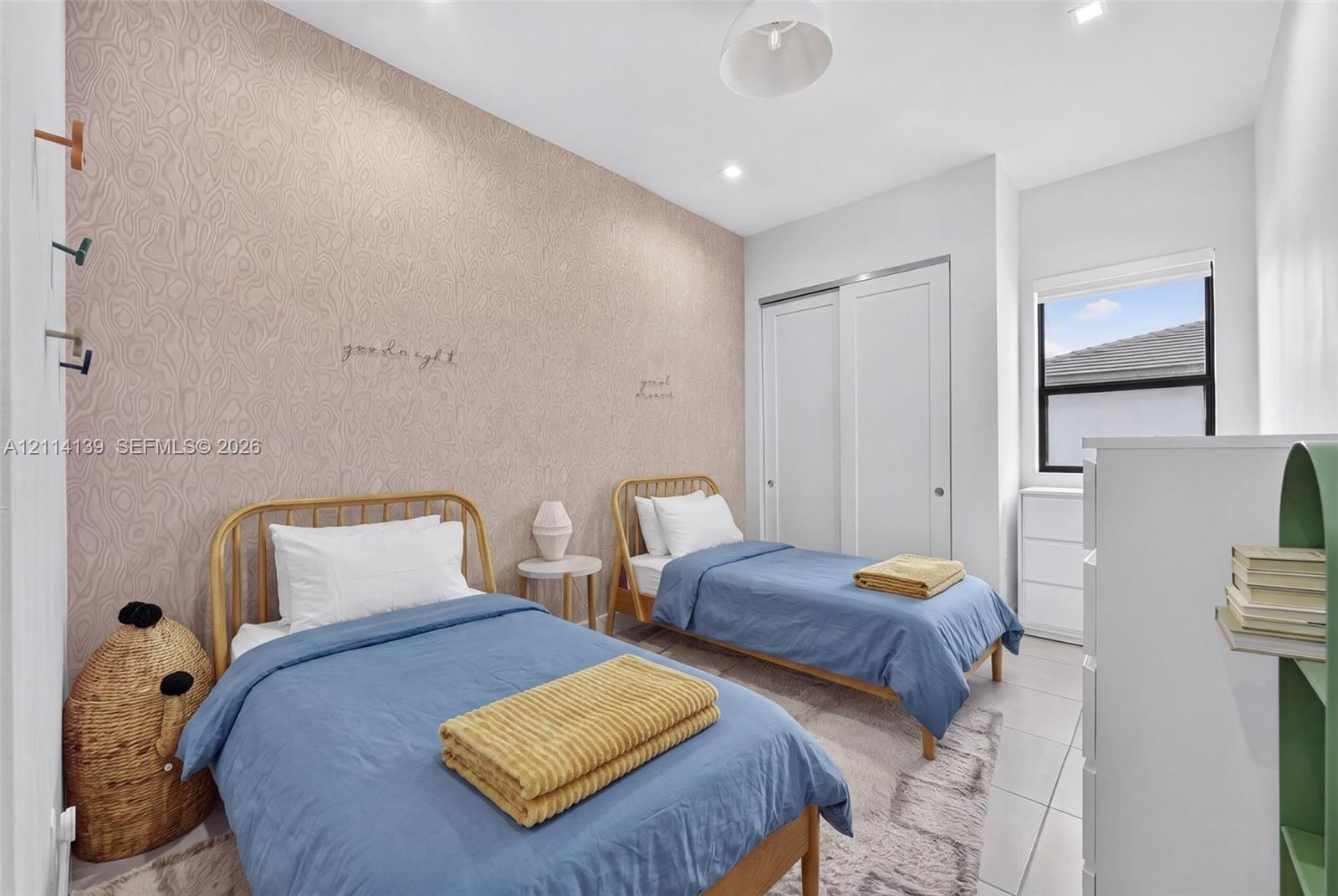 Neutral-toned bedroom featuring patterned wallpaper, tile flooring, recessed lighting, and a sliding-door closet