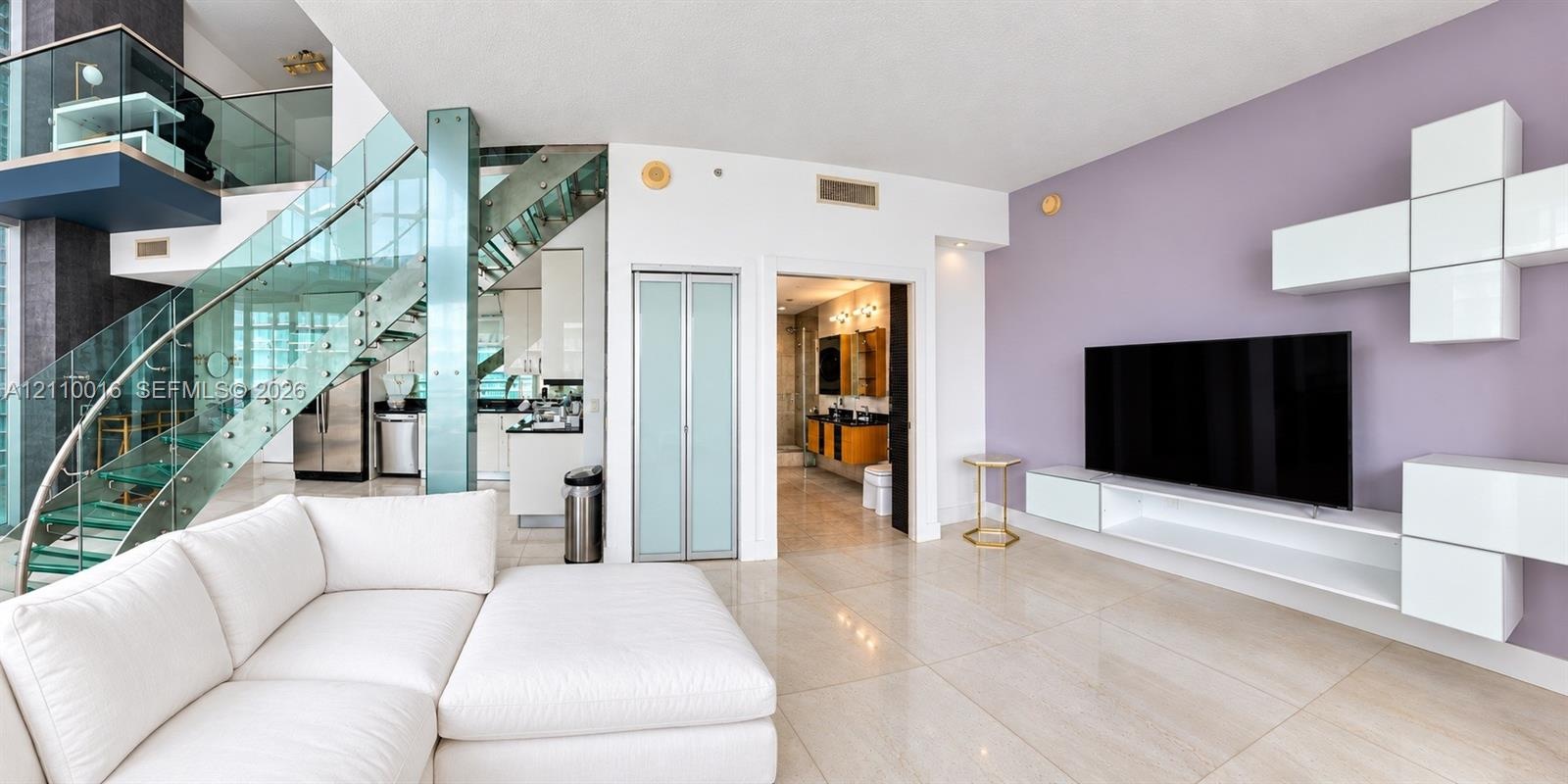 Floating glass staircase with metal structural supports, large-format tile flooring, built-in modular wall storage, and frosted glass paneled doors