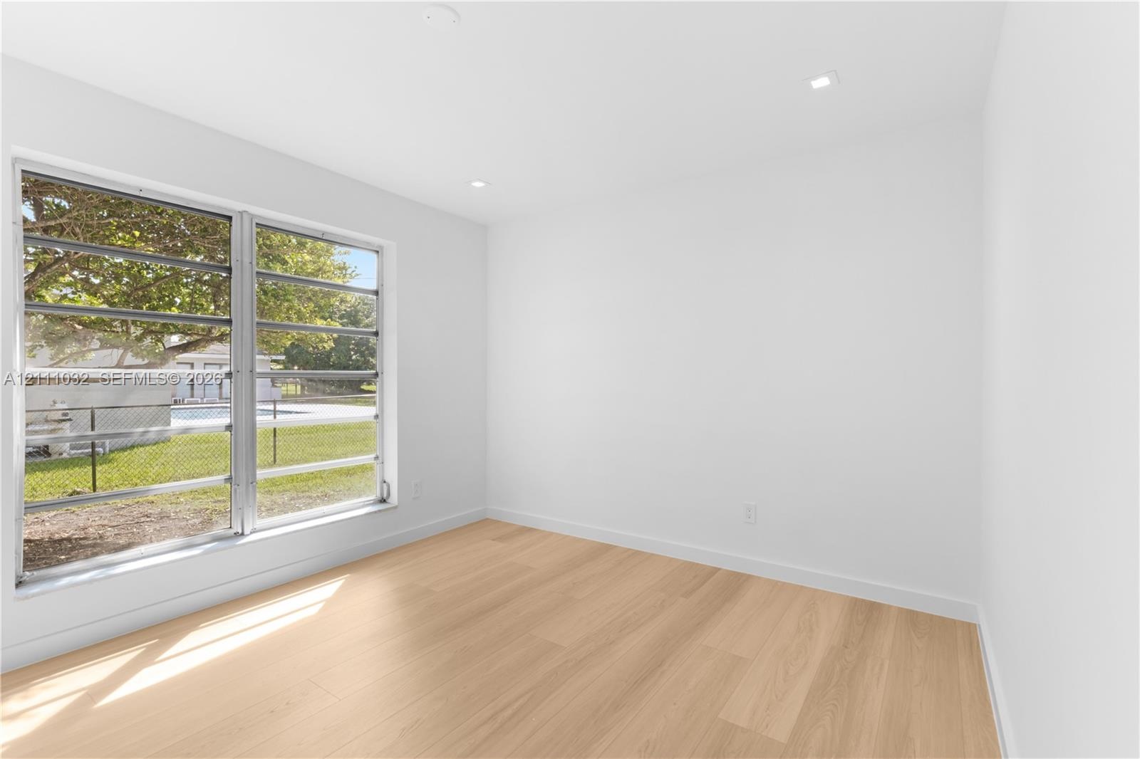 Bright interior space featuring wood-finish flooring, recessed lighting, and large horizontal sliding windows