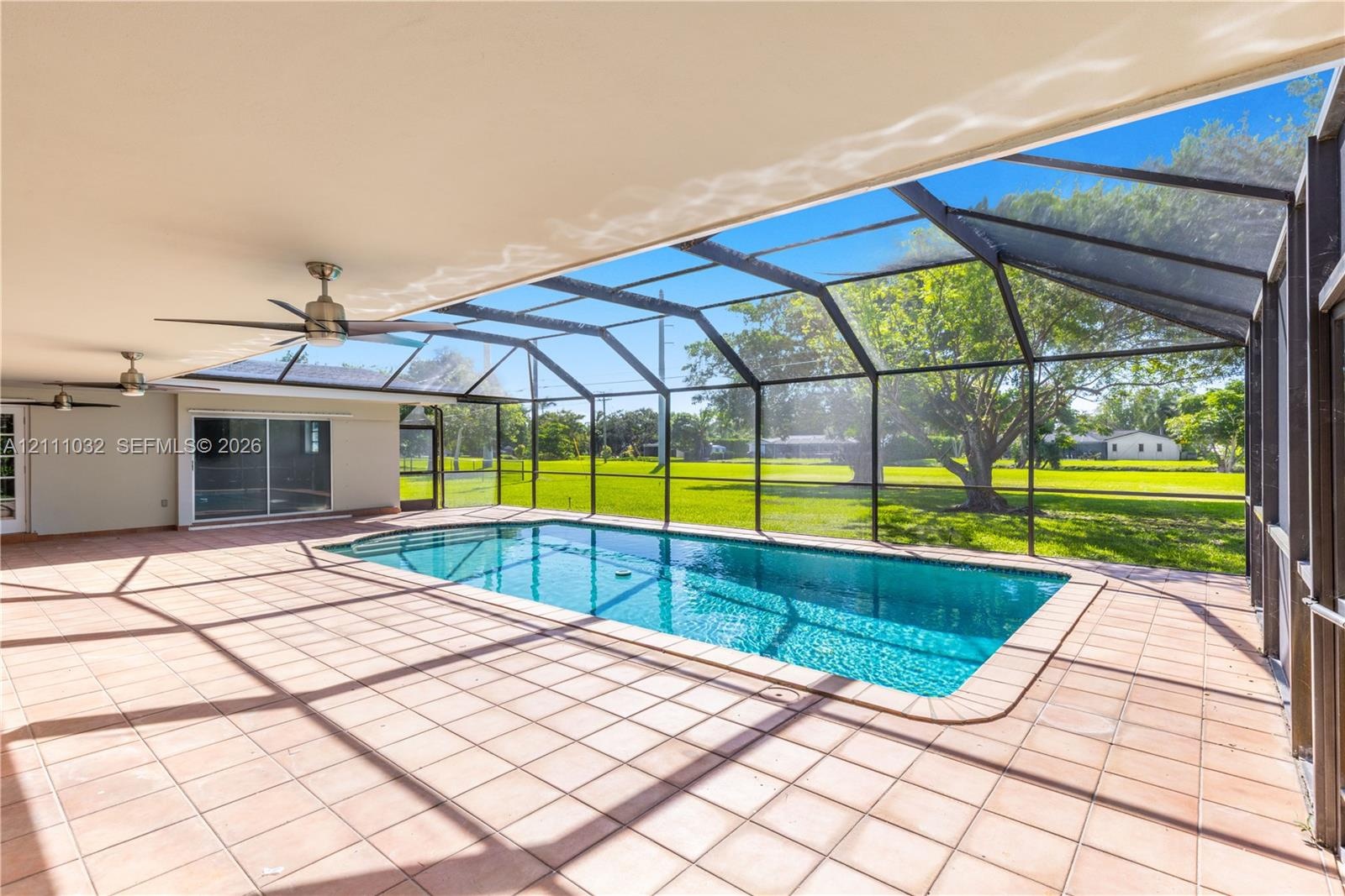 Screened-in patio featuring a tiled floor, recessed ceiling fans, and an inground swimming pool