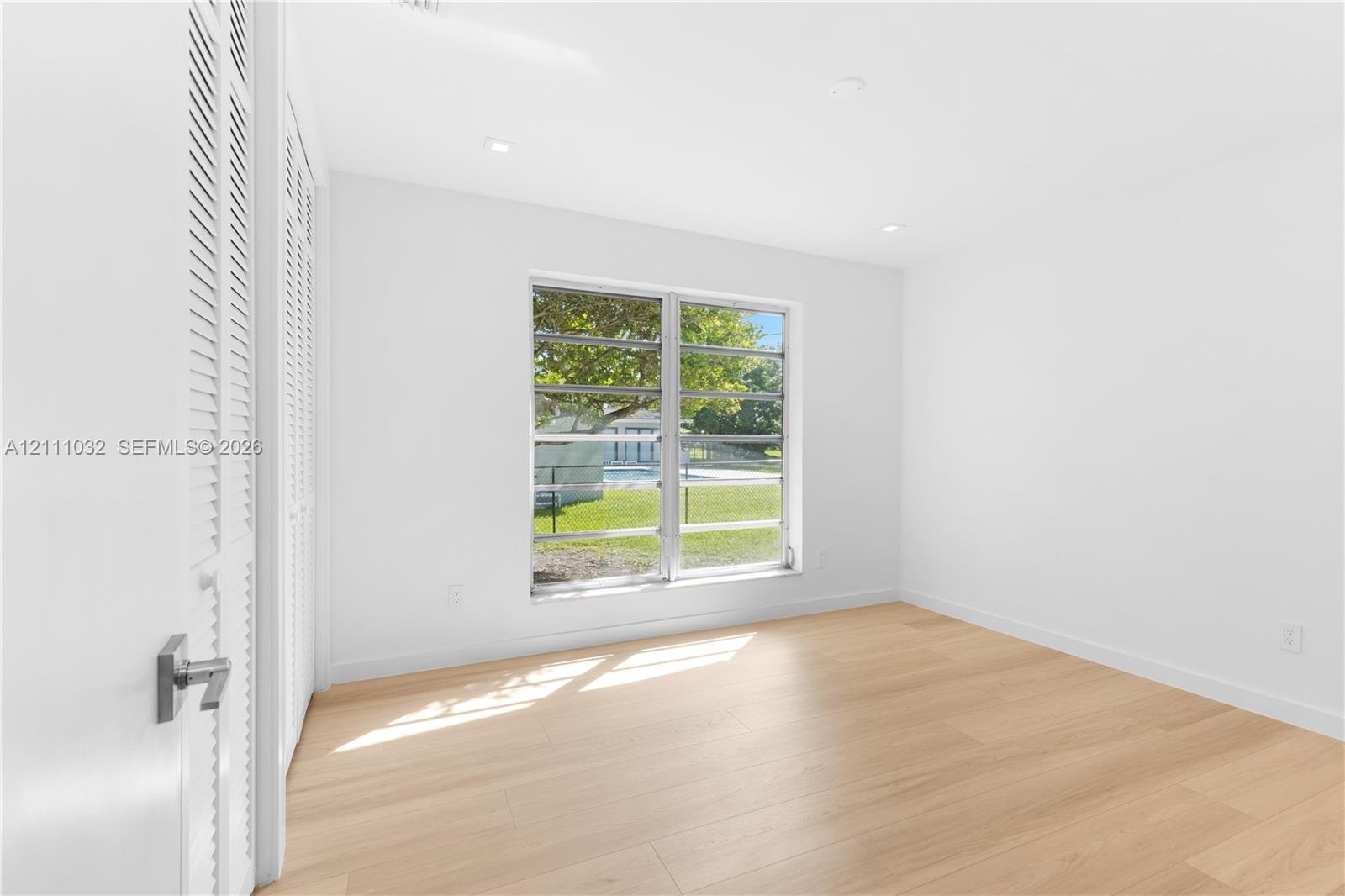 Room featuring wood-finish flooring, recessed lighting, and double louvered closet doors