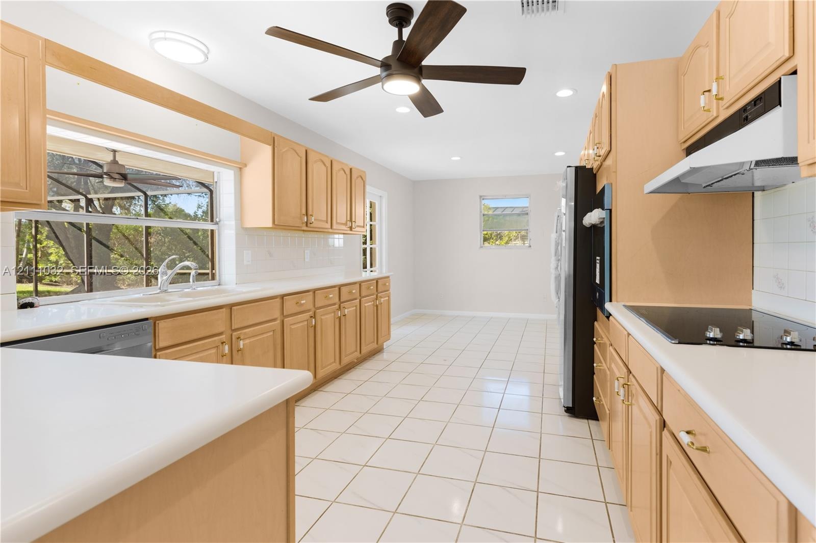 Kitchen featuring light-finish cabinetry, white solid-surface countertops, tile flooring, recessed lighting, and a ceiling fan
