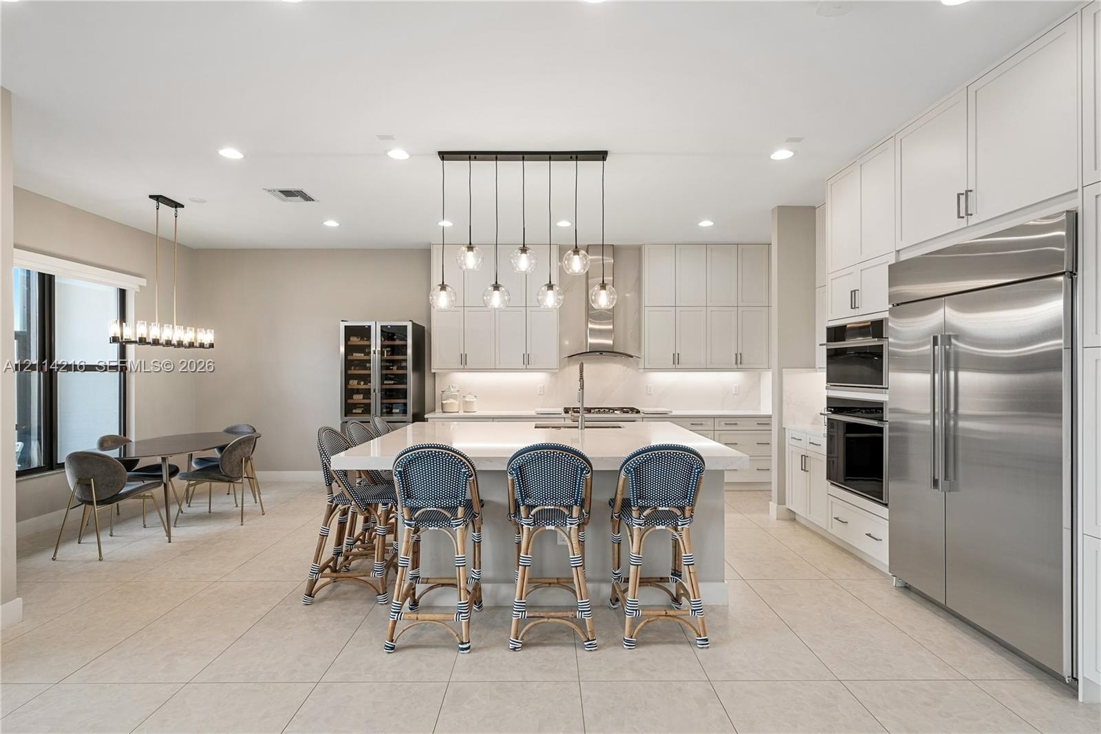 Kitchen featuring flat-panel cabinetry, a central island with a quartz countertop, professional-grade stainless steel appliances, a built-in wine refr