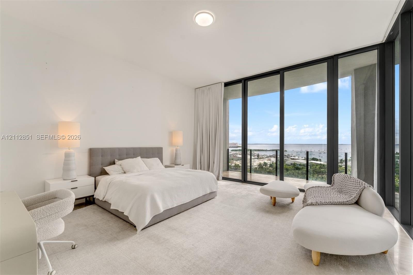 Floor-to-ceiling windows, sliding glass door, private balcony, neutral wall-to-wall carpeting, and recessed ceiling lighting
