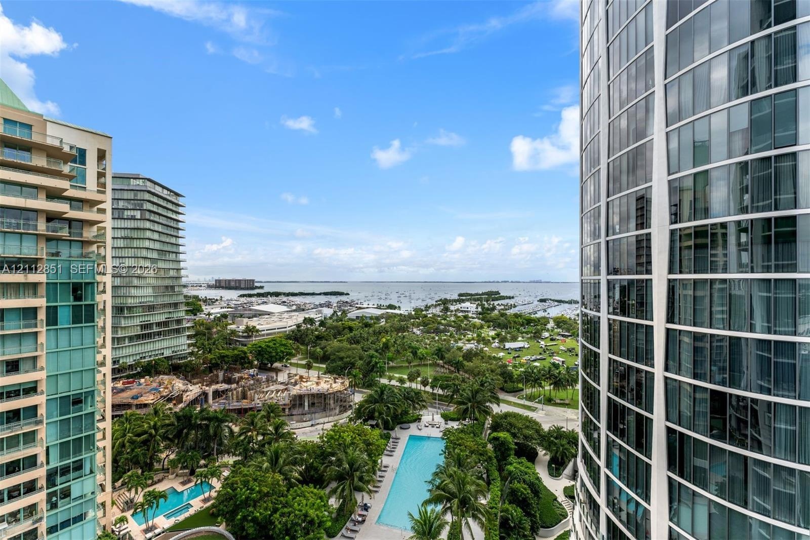 High-rise curtain wall construction, expansive floor-to-ceiling windows, and surrounding maritime landscape