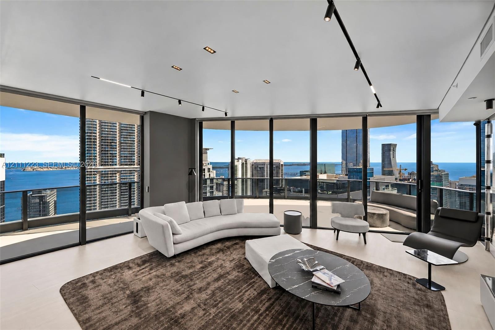 Floor-to-ceiling glass walls, wrap-around private terrace, smooth-finish ceiling with track lighting, and large-format tile flooring