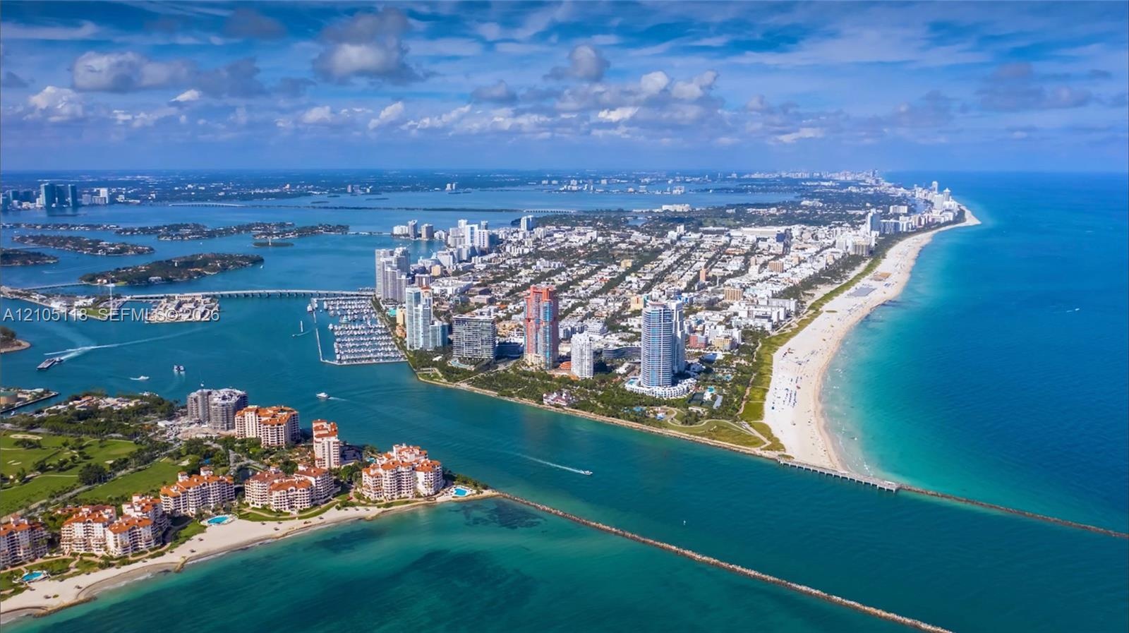 Aerial perspective of a coastal residential area featuring shoreline access, proximity to deep-water channels, extensive sandy beaches, and surroundin