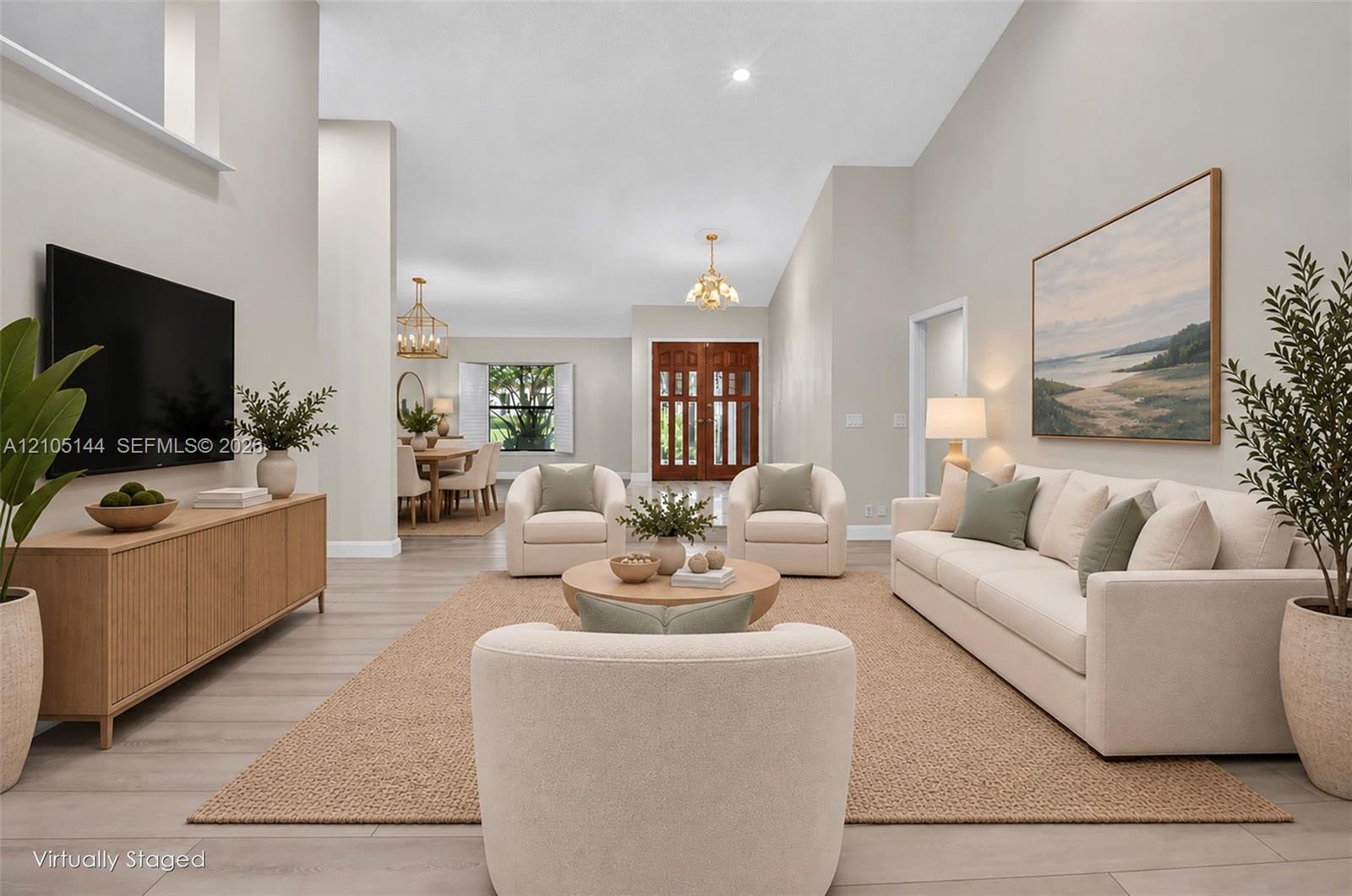 Spacious interior featuring vaulted ceilings, neutral wall tones, light wood-finish flooring, double front entry doors with glass panels, and multiple