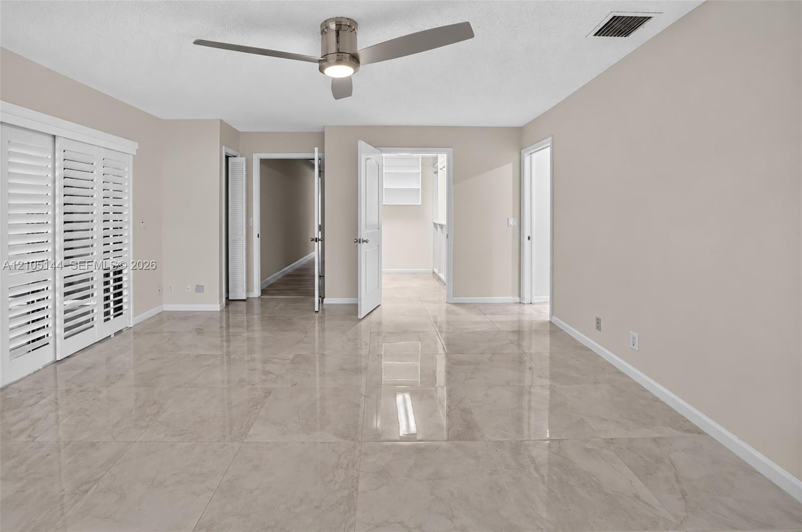 (FAN VIRTUALLY STAGED AS SIMILAR PIECE WILL BE INSTALLED) Interior space featuring high-gloss tile flooring, white plantation shutters, and a modern b