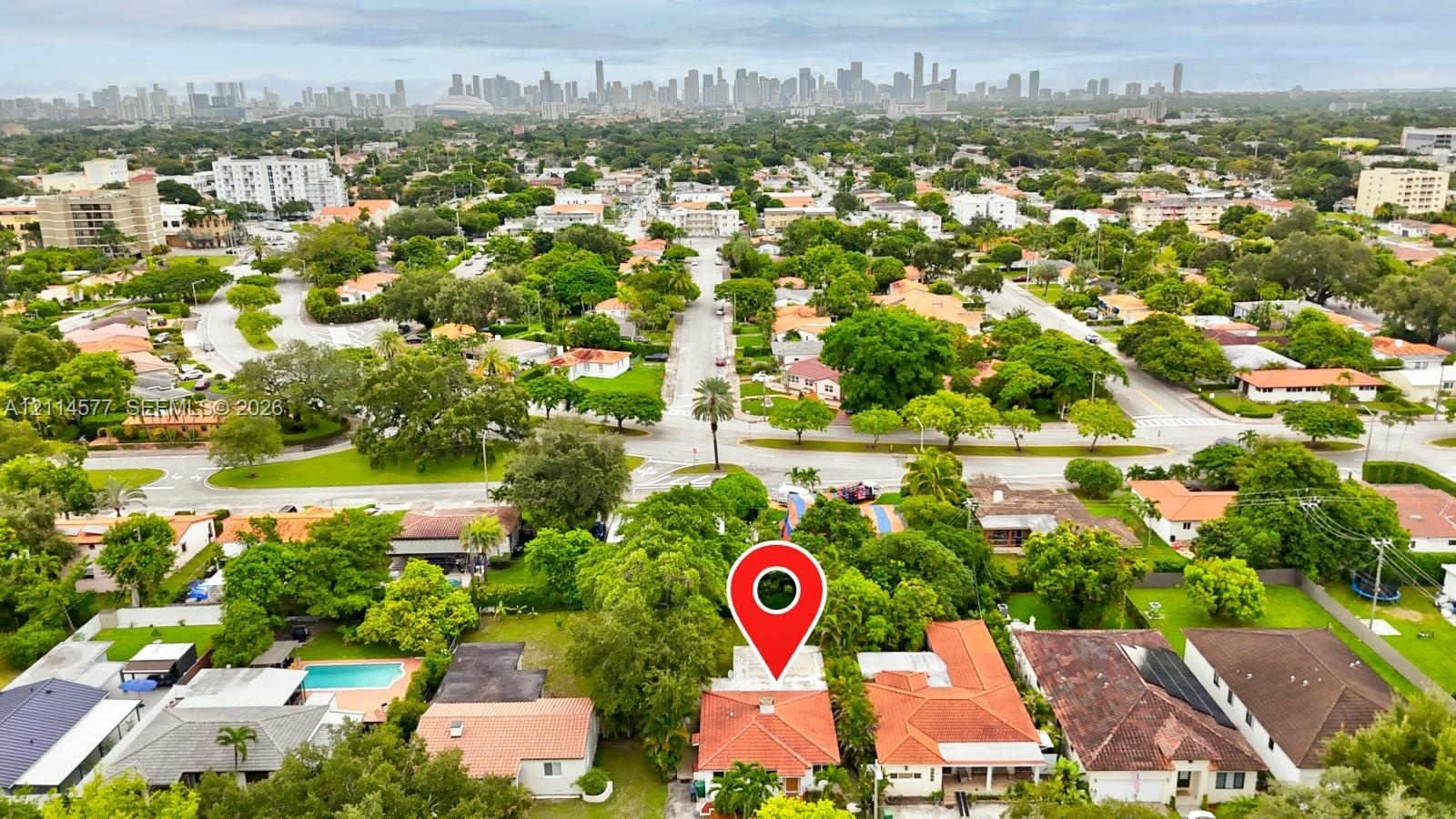 Aerial perspective featuring an orange-tiled roofline and a prominent urban skyline backdrop