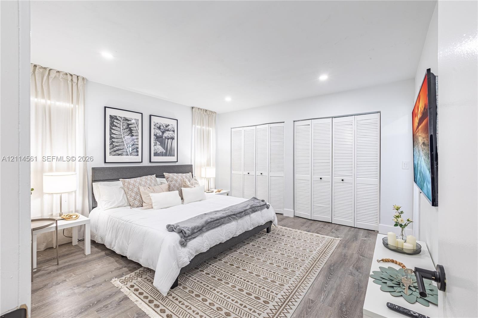 Wood-finish flooring, recessed lighting, and double-closet storage featuring white louvered doors