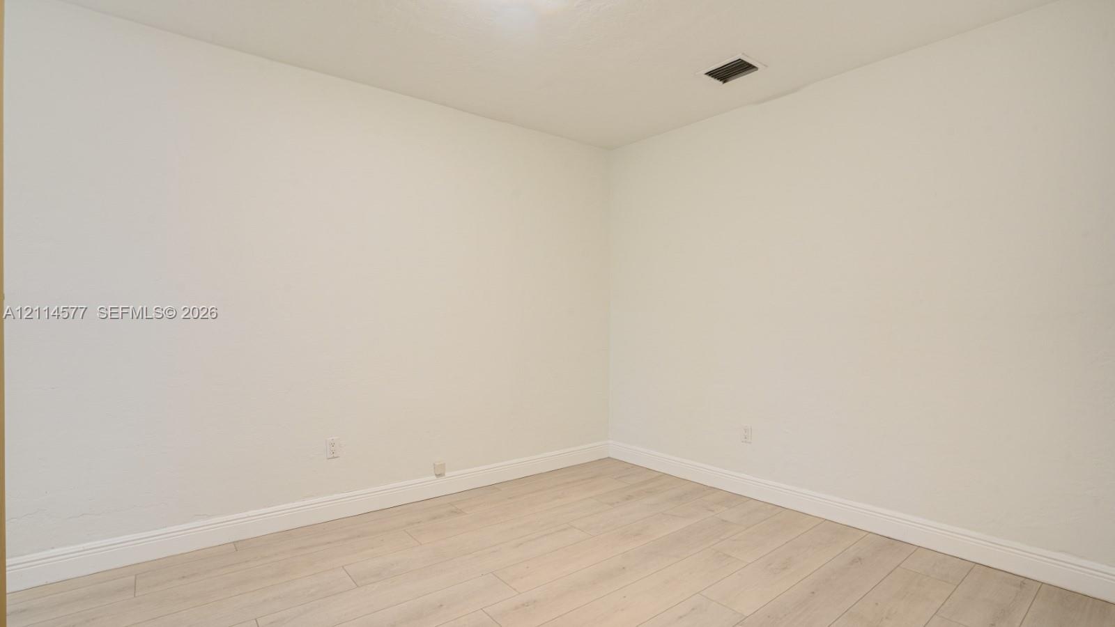 Neutral-toned interior space featuring light-colored wood-finish flooring and smooth wall surfaces