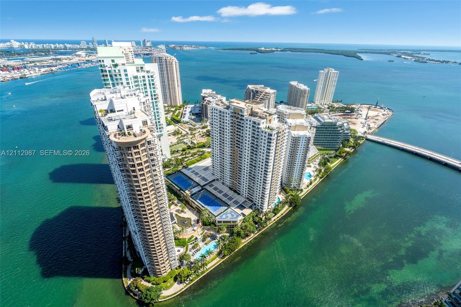 High-rise waterfront complex featuring multiple outdoor swimming pools, landscaped grounds, tennis courts, and immediate proximity to the Atlantic sho