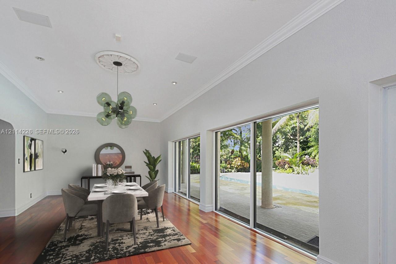 Spacious dining area featuring wood-finish flooring, a decorative ceiling medallion, recessed lighting, and expansive floor-to-ceiling sliding glass d