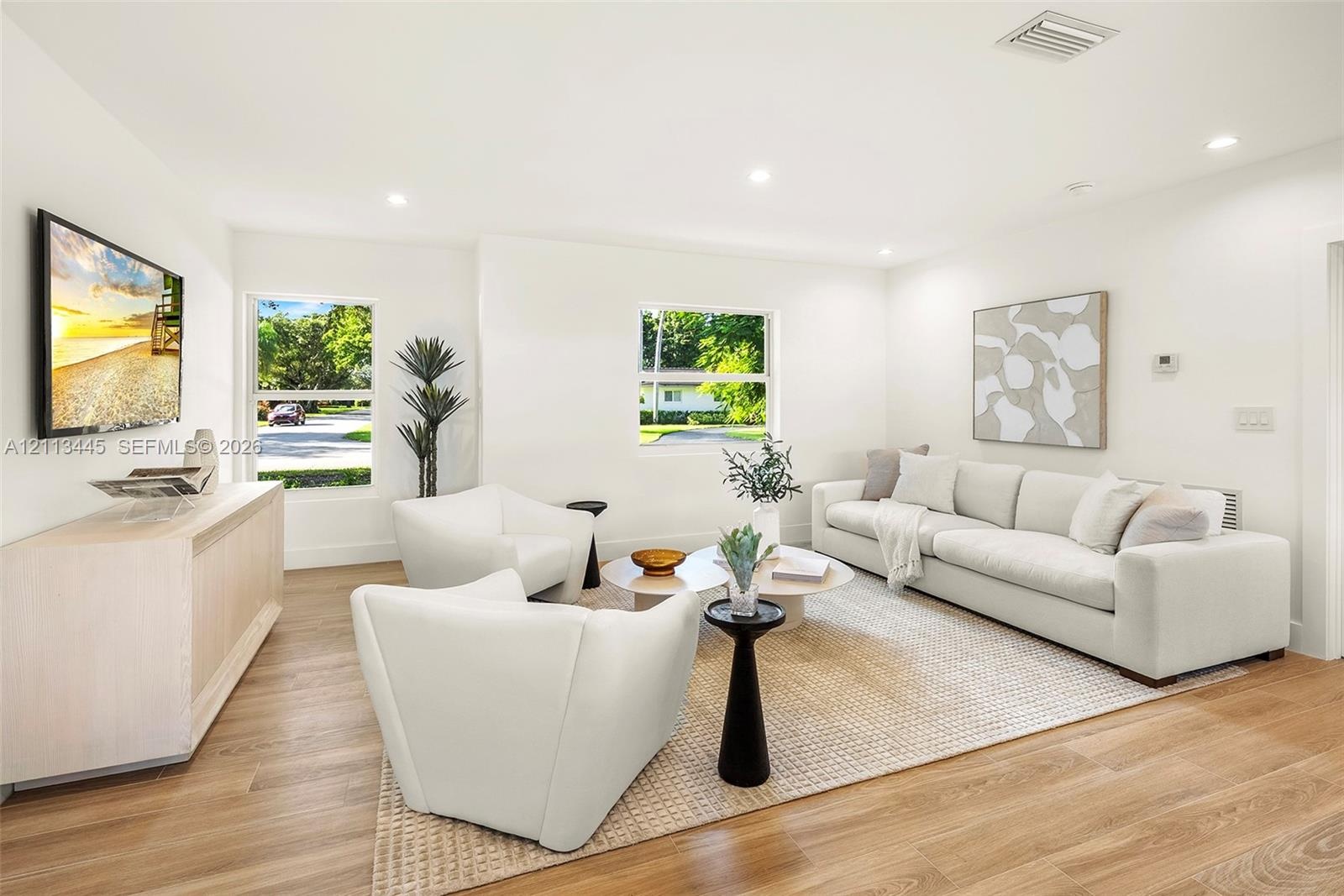 Living area featuring wood-finish flooring, recessed lighting, and multiple windows