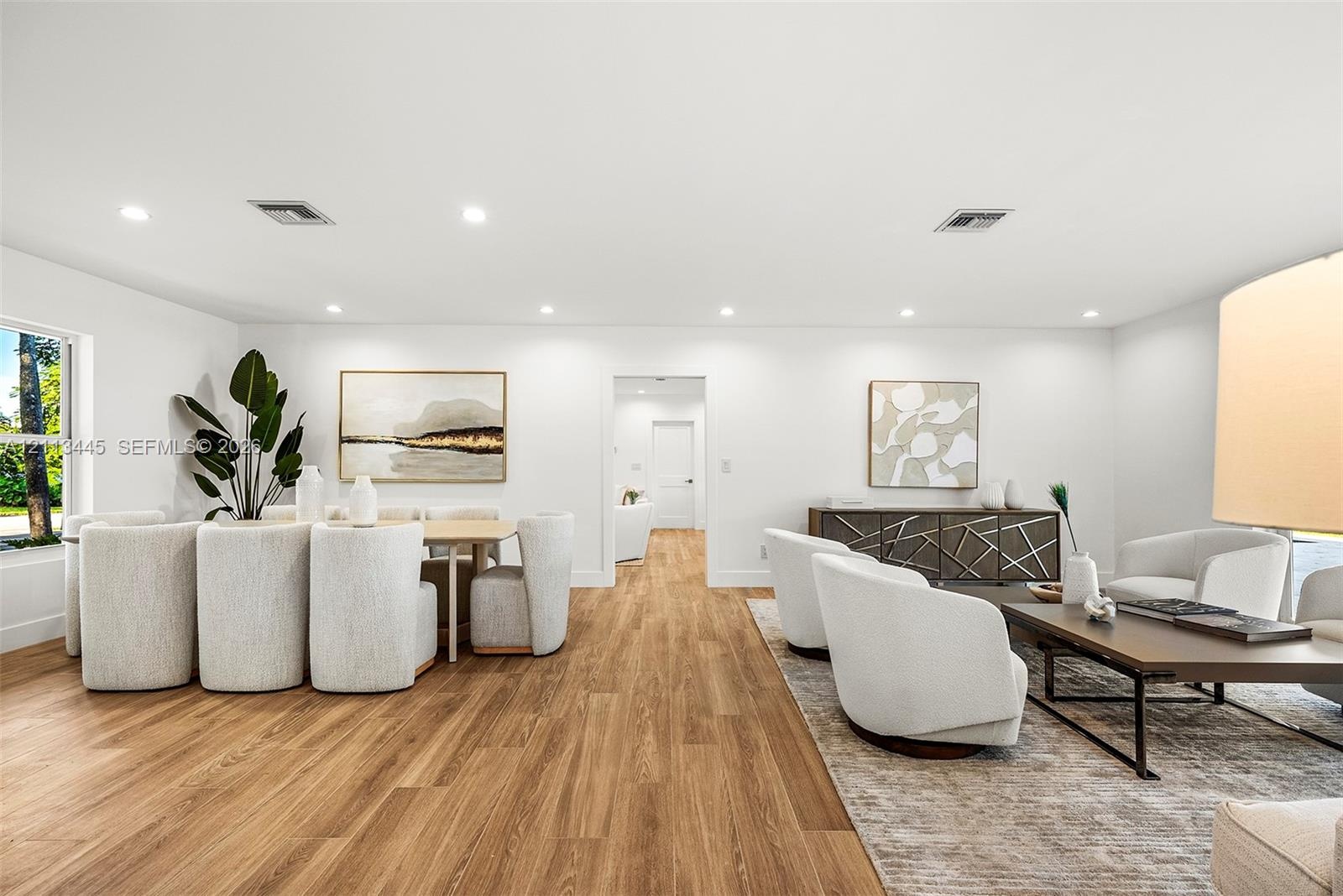 Open-concept interior featuring wood-finish flooring, recessed lighting, and crisp white wall finishes