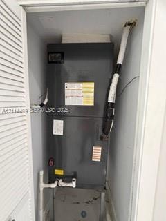 Vertical HVAC air handler unit enclosed within a closet featuring louvered bi-fold doors