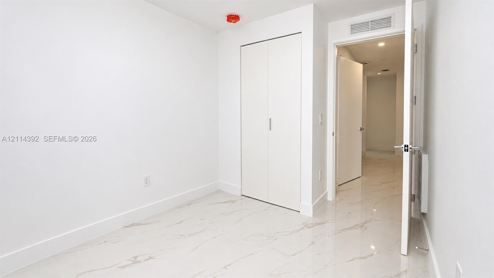 Stone-finish flooring, dual-panel closet doors, and recessed ceiling lighting