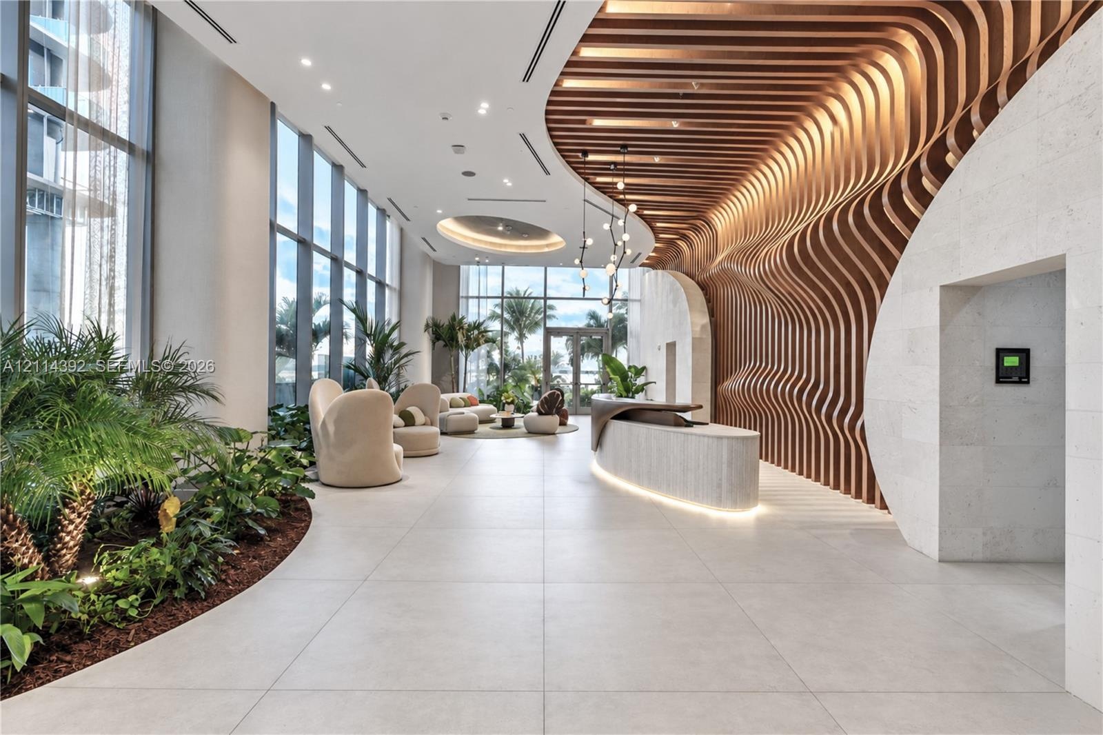 Lobby featuring large-scale floor-to-ceiling windows, parametric wood-slat ceiling detailing, stone-clad walls, large-format tile flooring, and integr