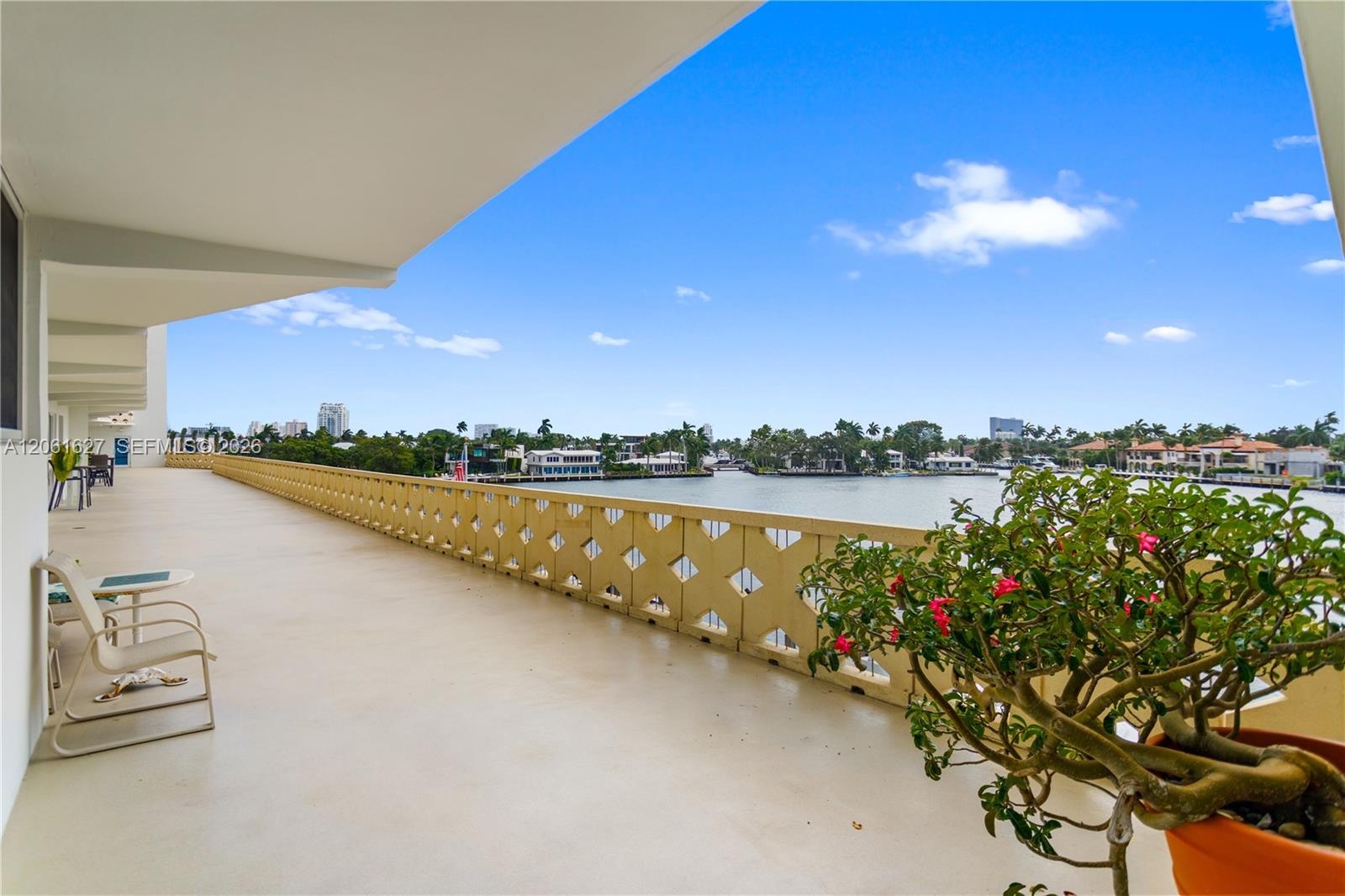 Expansive covered balcony featuring a geometric latticework railing and solid surface flooring with an open exposure to the water