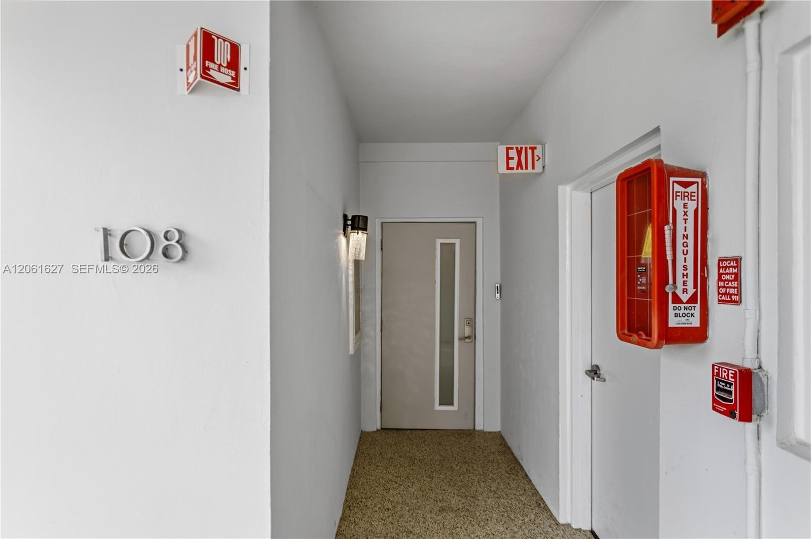 Entryway featuring neutral wall finishes, a door with an integrated vertical glass panel, modern wall-mounted sconce lighting, and textured flooring