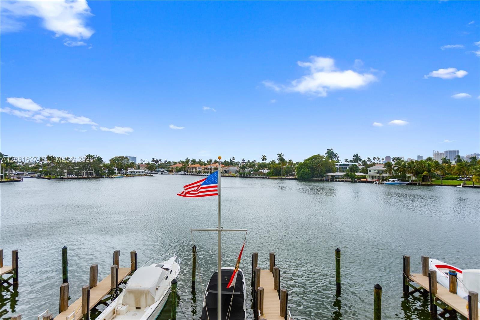 Waterfront property featuring multiple boat slips and a central dock-mounted flagpole
