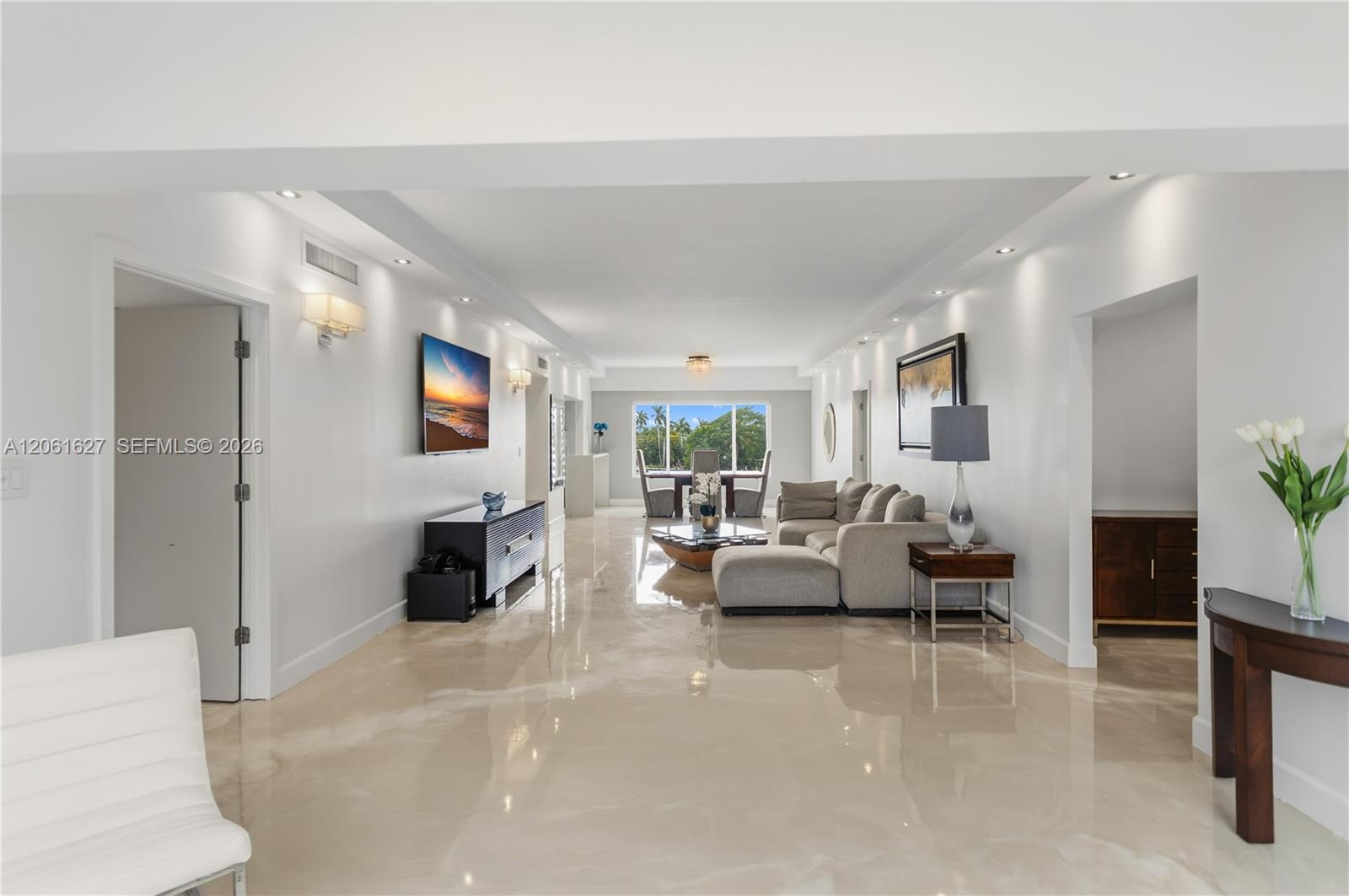 Polished stone flooring, recessed lighting, crown molding, and large picture windows featuring exterior greenery