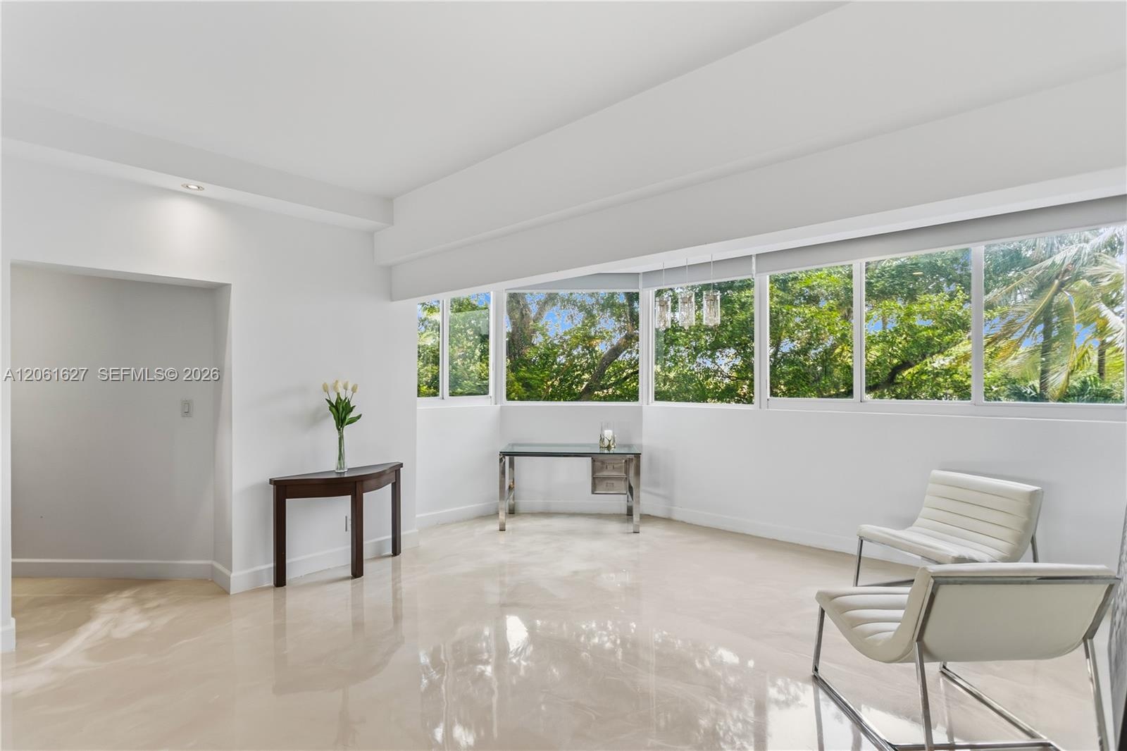 Polished stone flooring, expansive wrap-around windows, and recessed lighting