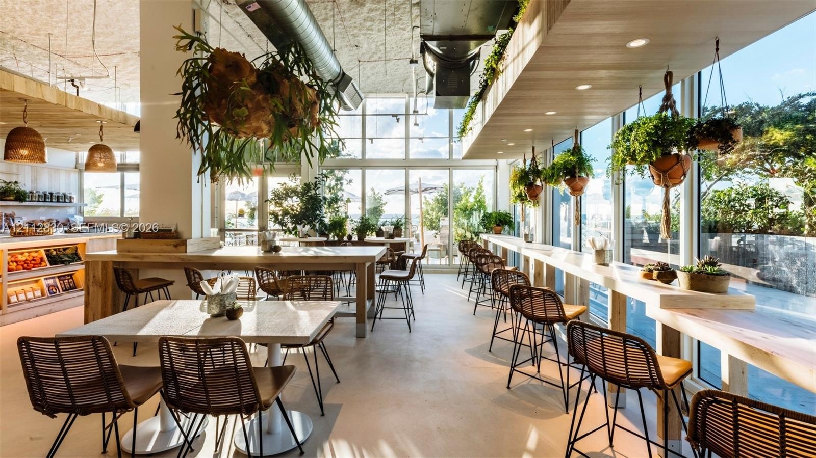 Expansive interior featuring floor-to-ceiling glass walls, exposed structural ductwork, custom light-toned wood-finish countertops, and recessed ceili