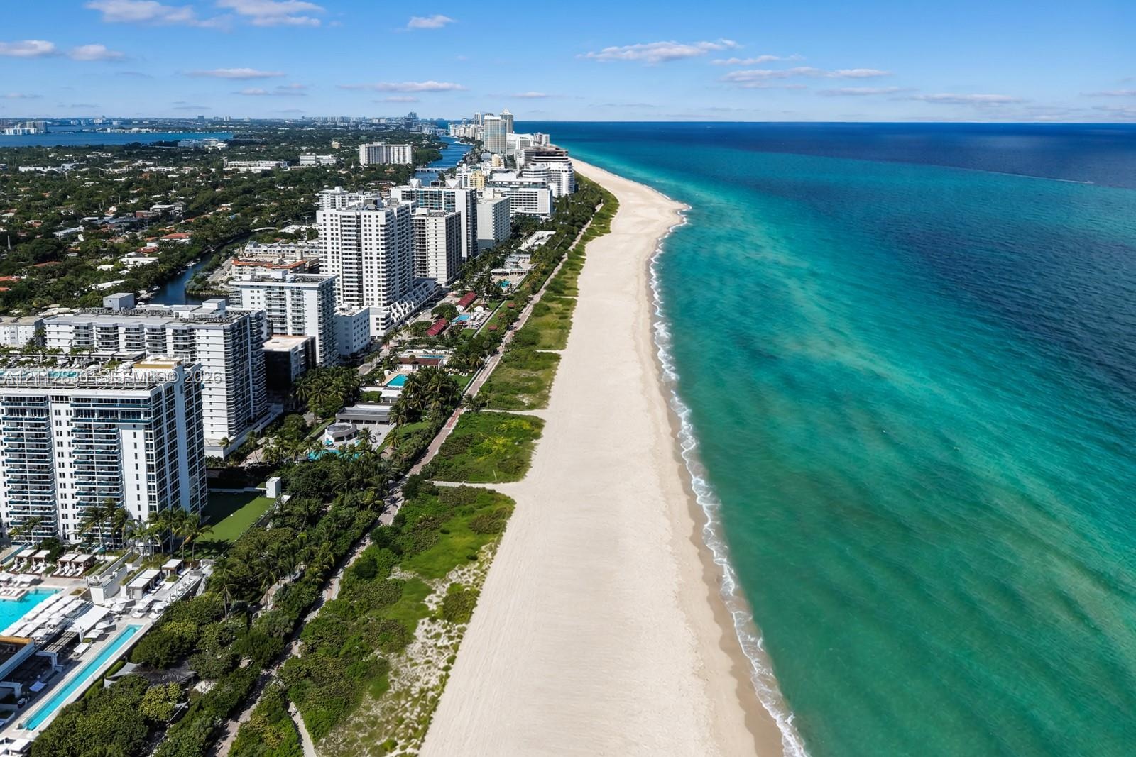 Aerial perspective of coastal high-rise development featuring direct oceanfront access, sandy shoreline, and proximity to Atlantic waters
