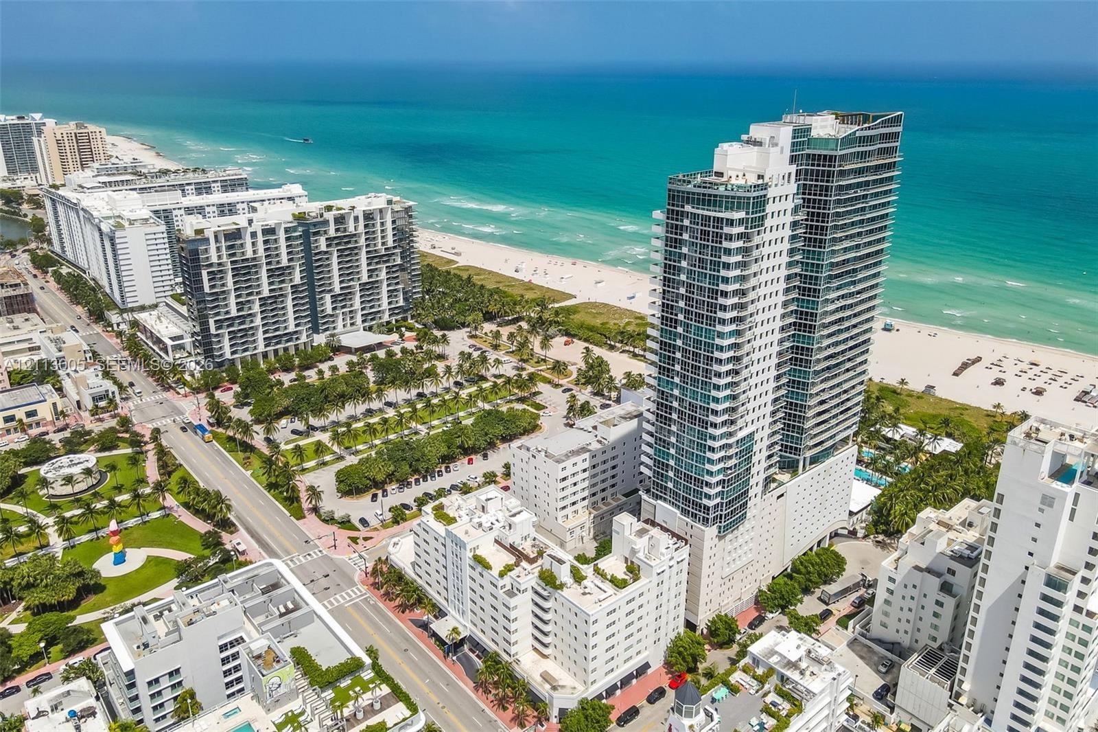 High-rise residential tower featuring glass-paneled balconies and direct proximity to the Atlantic Ocean coastline