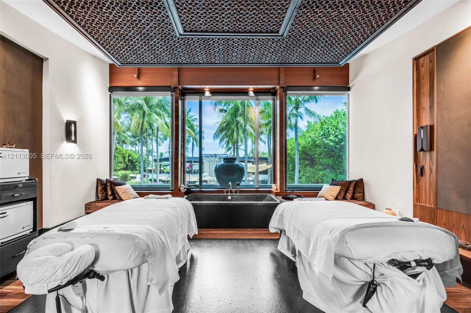 Custom-designed recessed ceiling with decorative screen detailing, built-in wooden wall paneling, large-format picture windows, and integrated soaking