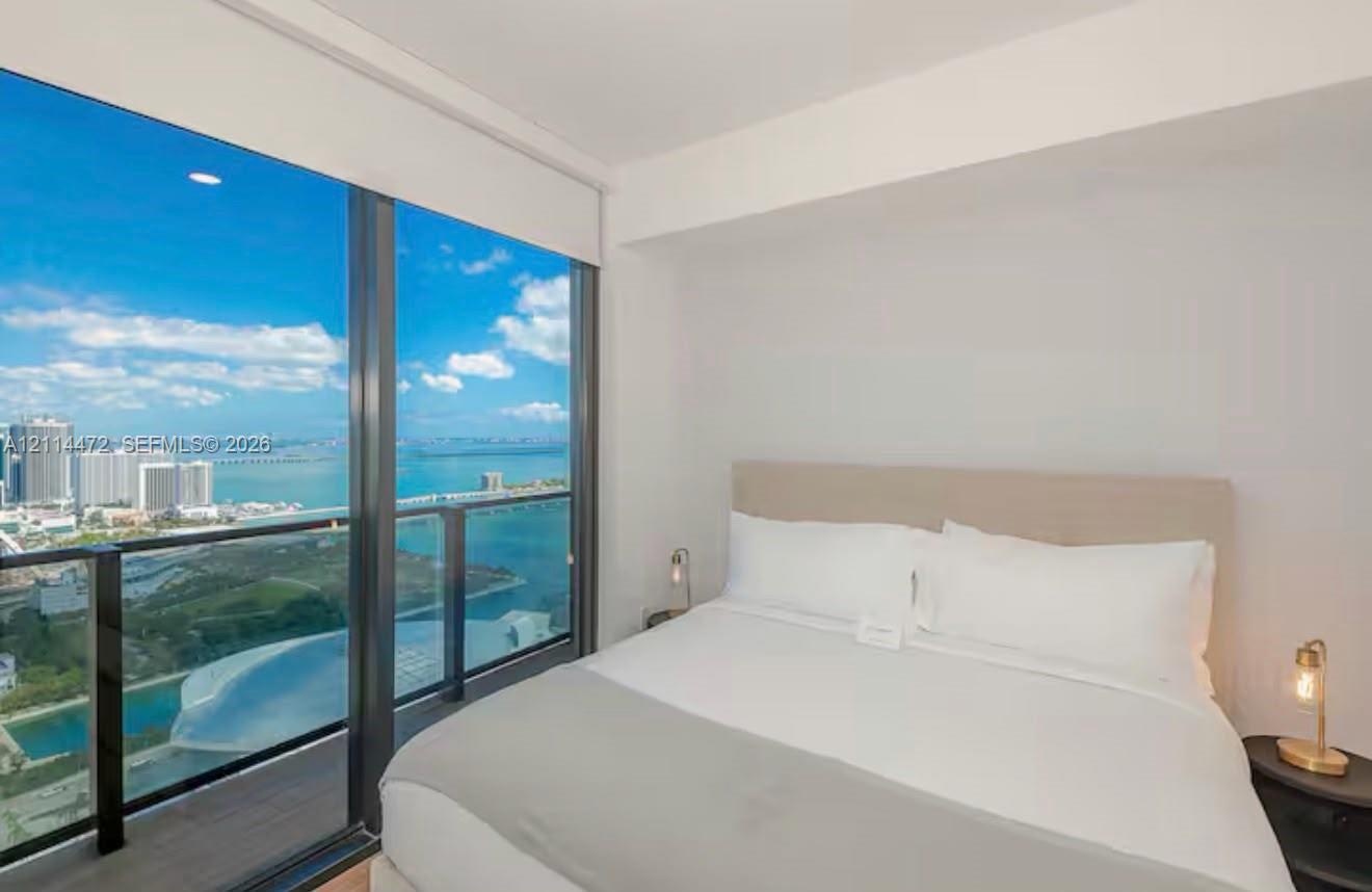 Floor-to-ceiling windows, access to a private balcony, metal railing system, and recessed ceiling lighting