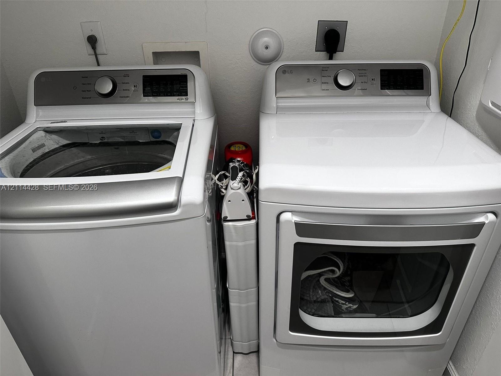 Top-loading washing machine and front-loading dryer with metallic-finish accents and digital control panels