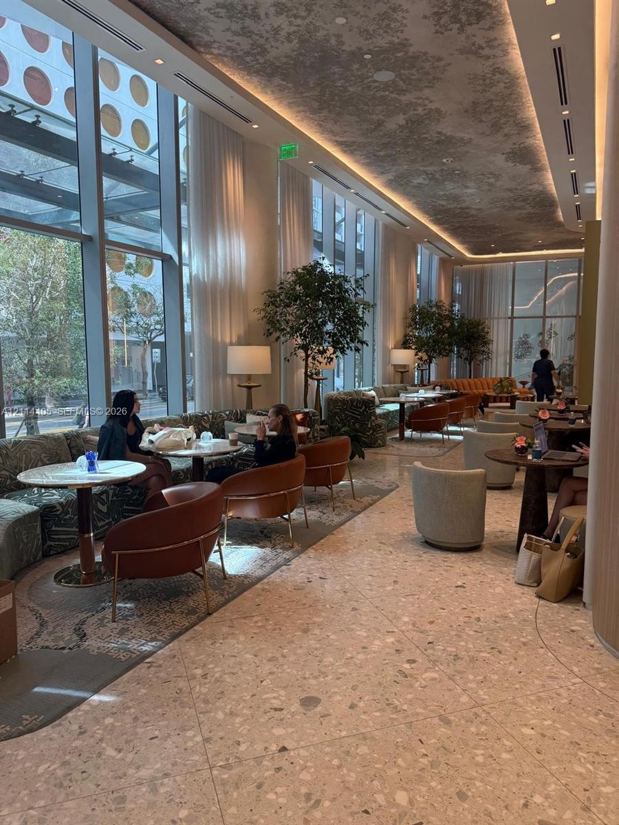 Floor-to-ceiling windows, terrazzo flooring, recessed cove lighting, and decorative ceiling treatment