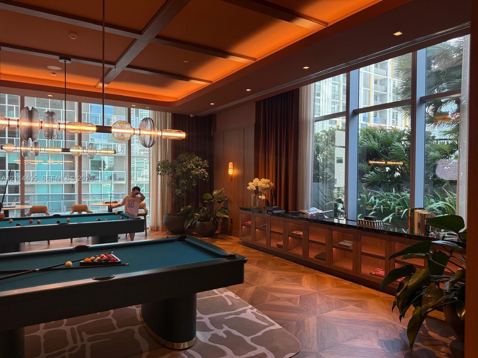Coffered ceiling featuring recessed lighting, expansive floor-to-ceiling windows, built-in lower cabinetry with stone surfacing, and intricate geometr
