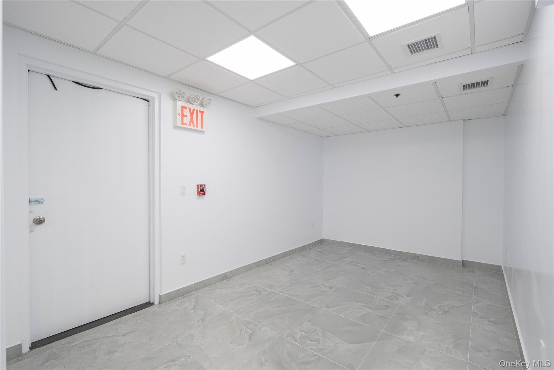 Finished basement with baseboards and a drop ceiling