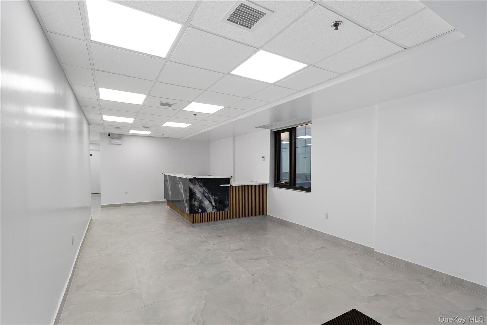 Empty room with baseboards and a paneled ceiling