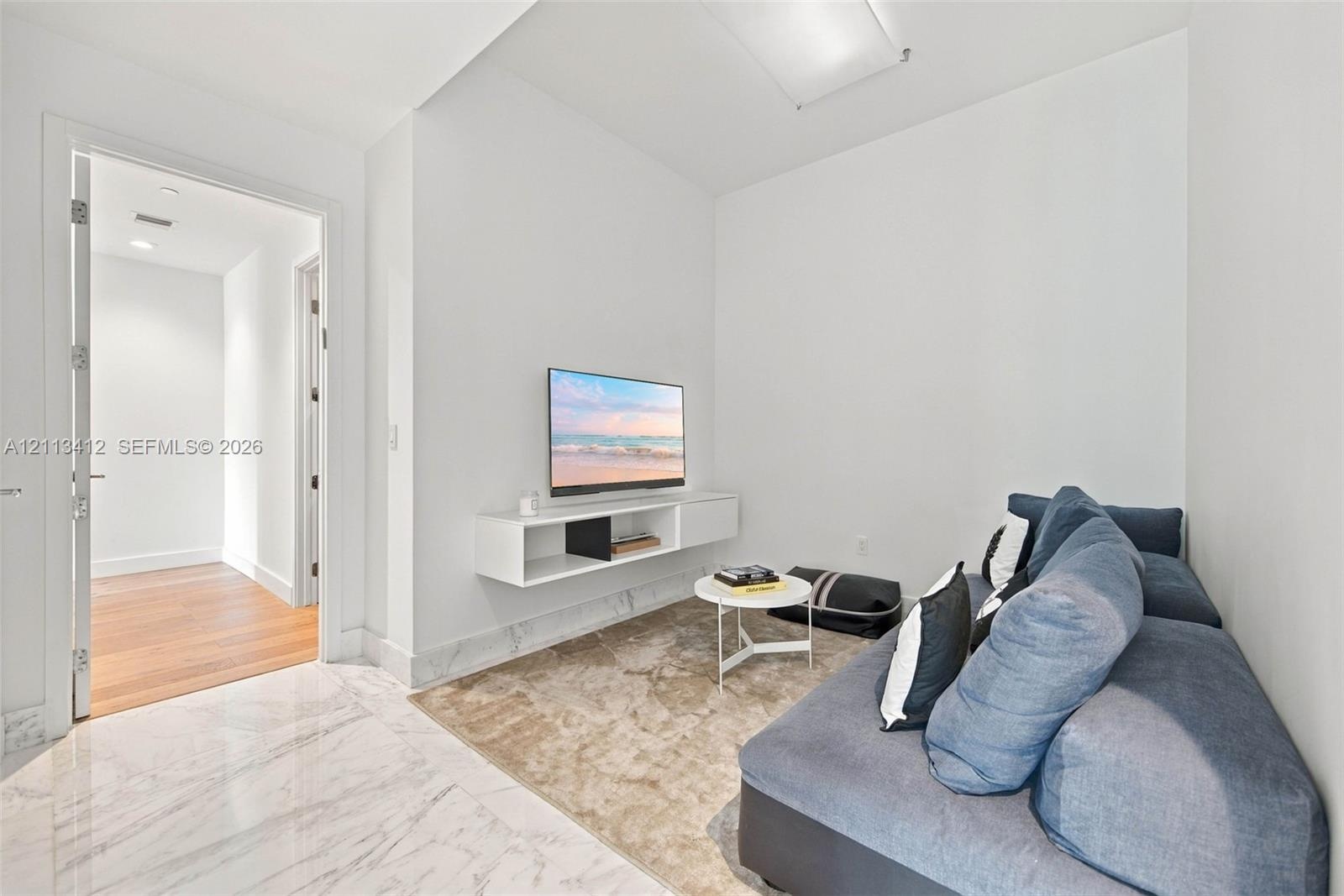 Polished stone flooring, wood-finish flooring, and wall-mounted white cabinetry