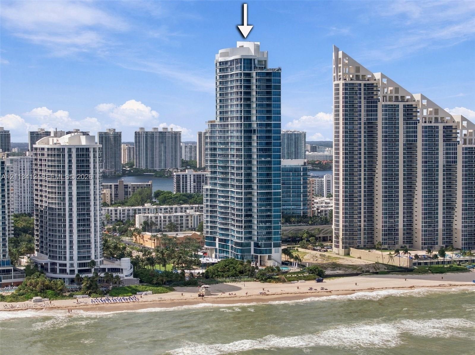 High-rise residential tower featuring a glass-facade exterior, private balconies, and an oceanfront location