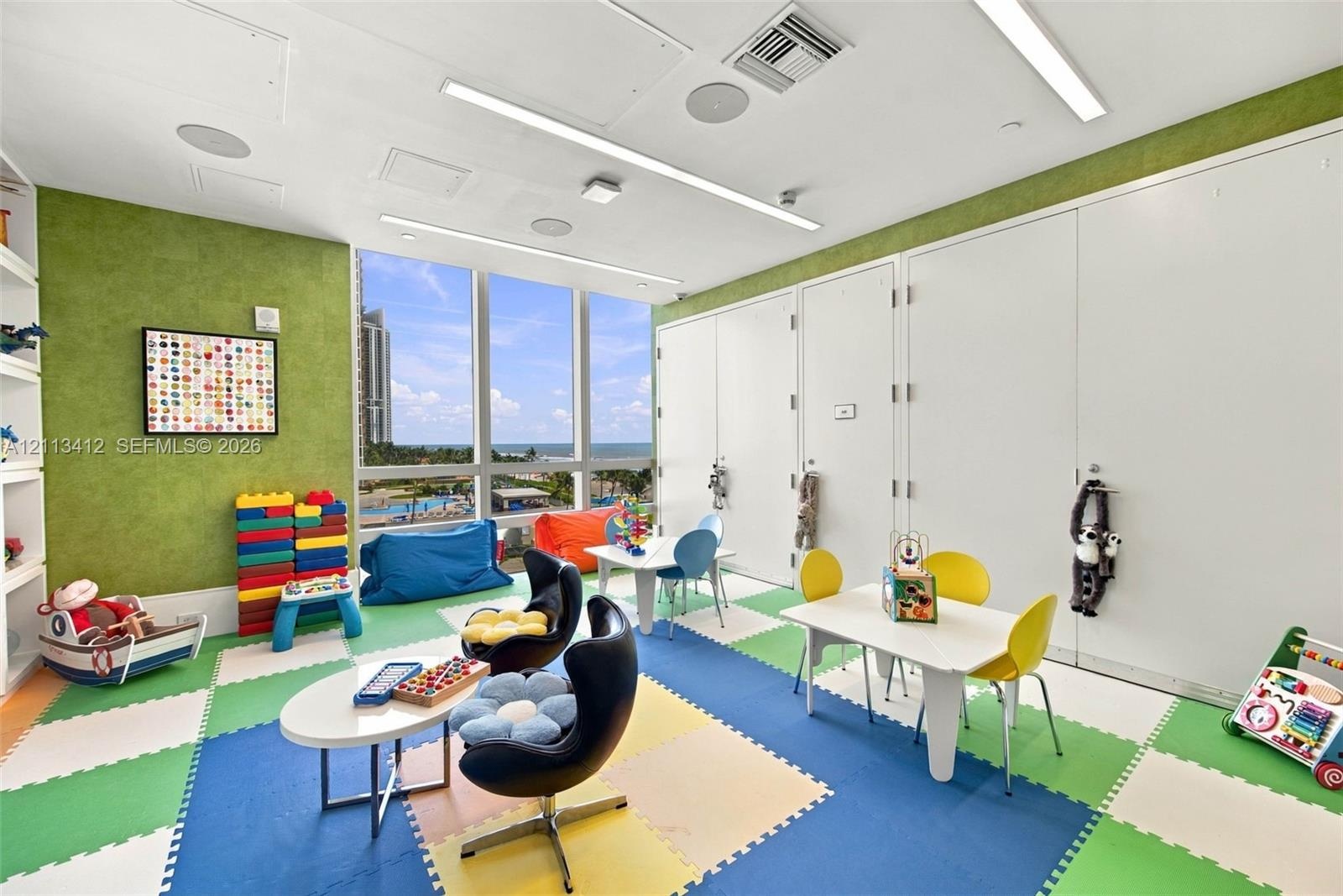 Floor-to-ceiling windows, built-in shelving, recessed ceiling lighting, and large-format tile flooring