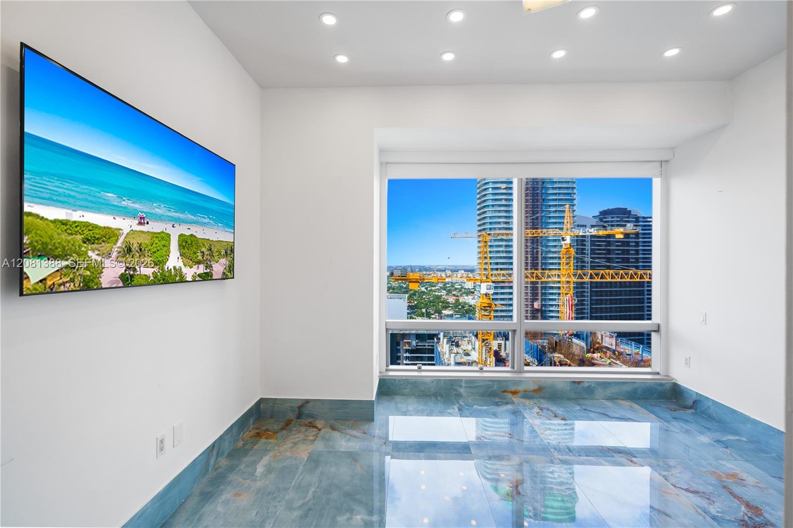 Floor-to-ceiling window featuring city skyline backdrop, polished blue-toned stone flooring, and recessed ceiling lighting