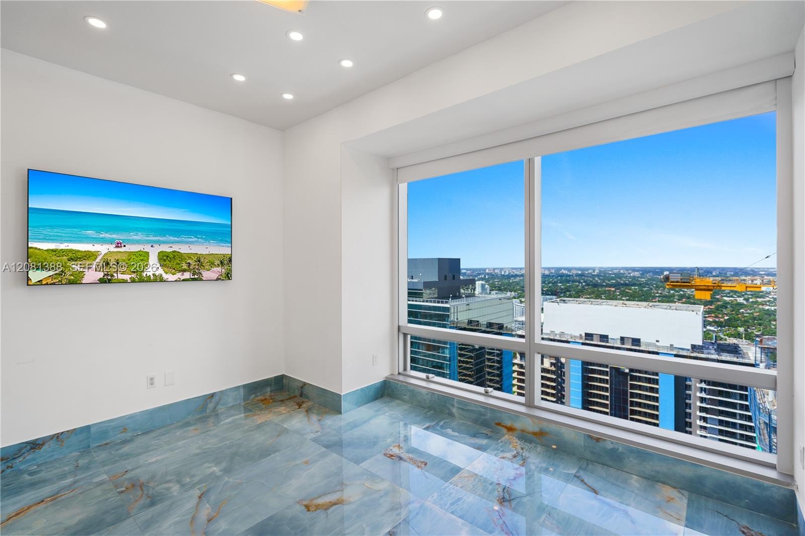 Floor-to-ceiling windows, blue-toned polished stone flooring, and recessed ceiling lighting