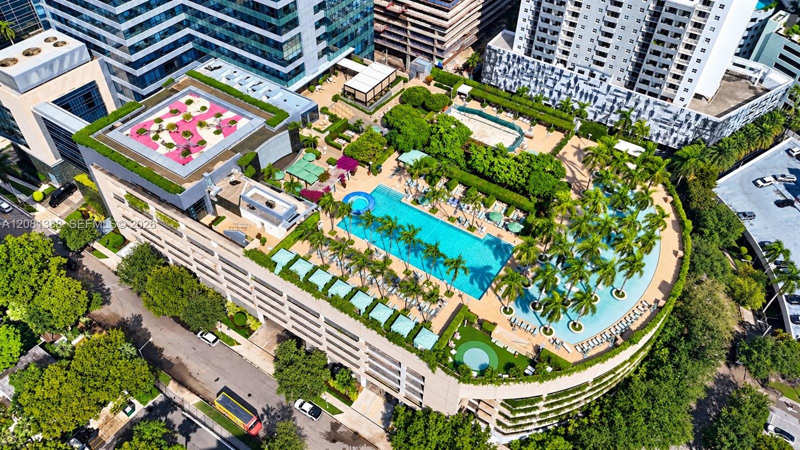 Rooftop deck featuring a swimming pool, wading area with palm trees, manicured landscaping, and a putting green