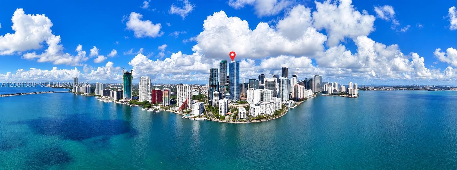 Panoramic aerial perspective of a high-rise urban skyline situated on a coastal peninsula with expansive surrounding waterfront