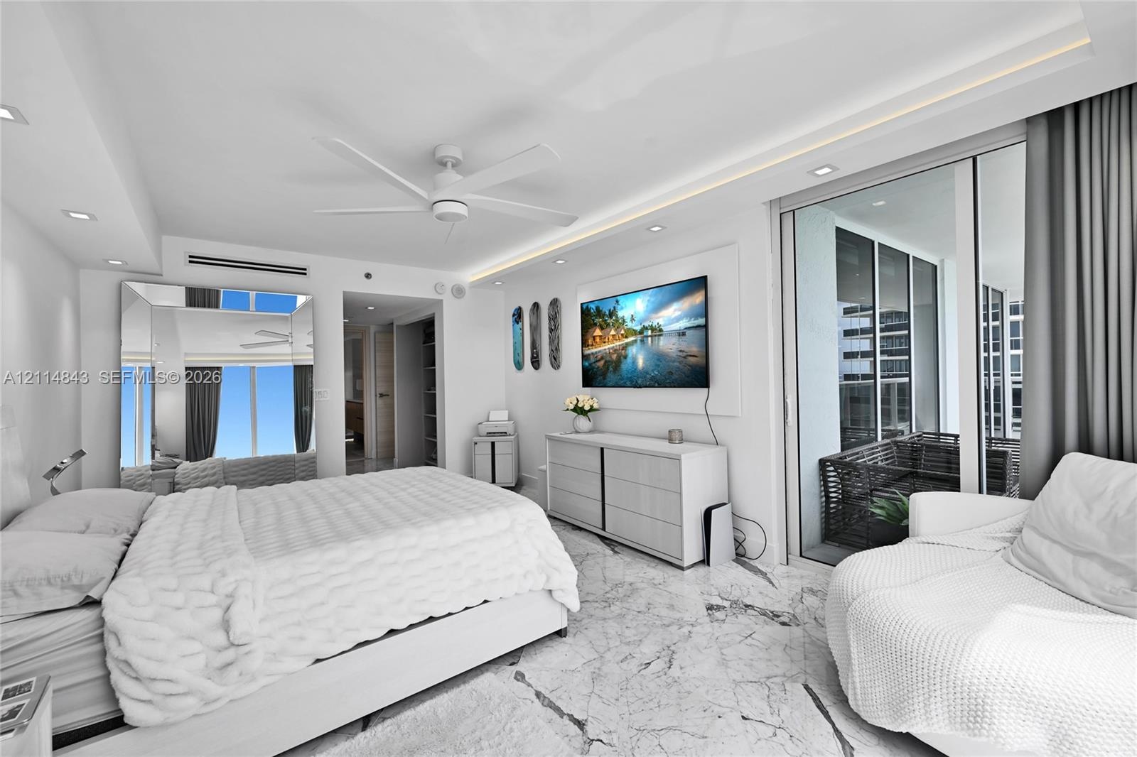 Stone flooring, tray ceiling with recessed lighting, floor-to-ceiling glass sliding doors, and ceiling fan