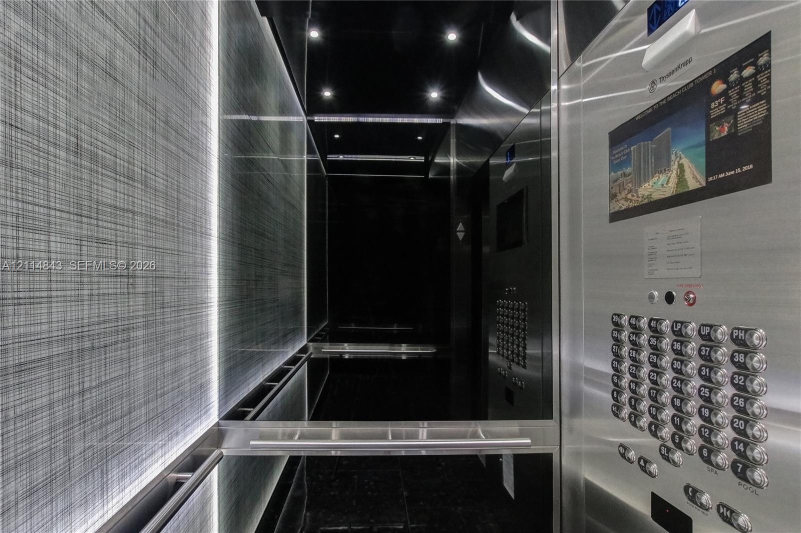 Modern elevator cab featuring stainless steel paneling, textured wall treatments, integrated recessed lighting, and a brushed metal handrail