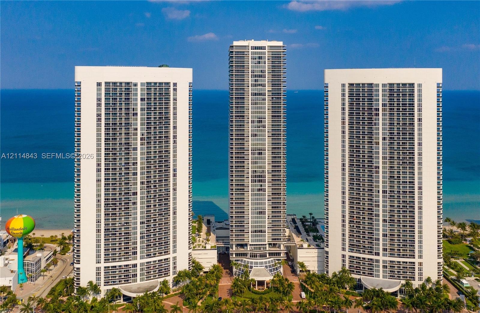 High-rise residential towers featuring glass-paneled balconies and direct oceanfront positioning